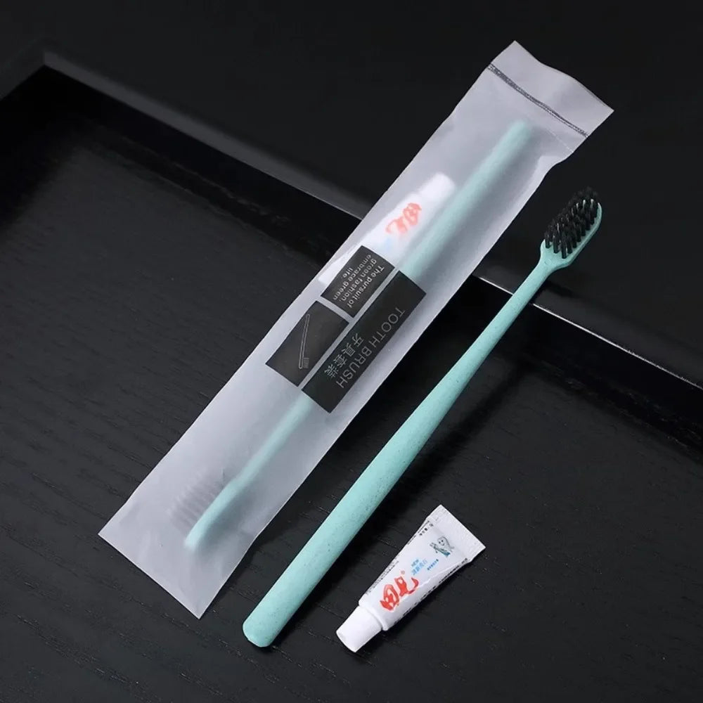 Mint green toothbrush with packaging and toothpaste on a black surface